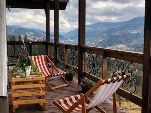 斯拉夫西克AGORA Chalet的山景阳台上配有两把椅子和一张桌子