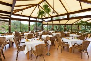 a restaurant with white tables and chairs and windows at Parque Vacacional Eden in Puerto de la Cruz +43 photos