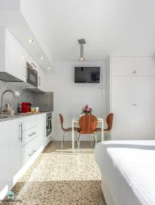 エンプリアブラバにあるHolidays P4の白いベッドルーム(テーブル付)、キッチン