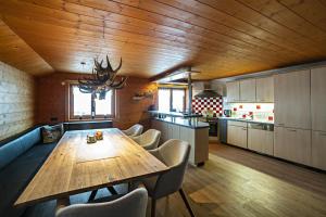 a large kitchen with a wooden table and chairs at Bergwelt-M in Schröcken