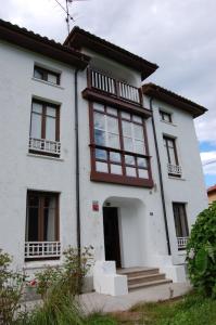 une maison blanche avec des ornements bruns et des fenêtres dans l'établissement La Casona de Narganes, à Narganes