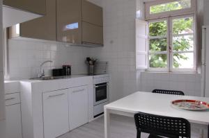 a kitchen with white cabinets and a table and a window at Gestiona2R - Narganes Mar y Montaña, ideal familias in Narganes