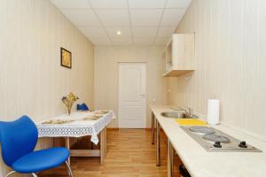 a kitchen with a sink and a table with blue chairs at Holiday Home Viktorija B in Jūrmala +13 photos