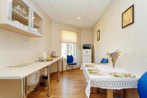 a kitchen and dining room with a table and blue chairs at Holiday Home Viktorija B in Jūrmala