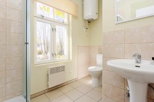 a bathroom with a sink and a toilet and a window at Holiday Home Viktorija B in Jūrmala