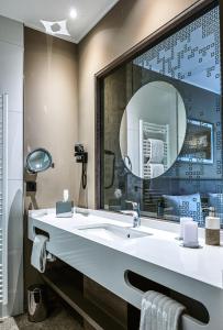 a bathroom with a sink, mirror, and bathtub at Waldhaus Jakob in Konstanz