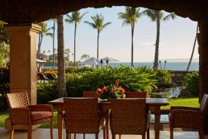 a table and chairs with a view of the ocean at Wailea Beach Villas in Wailea