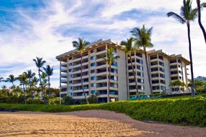 un gran edificio en la playa con palmeras en Polo Beach Club - CoralTree Residence Collection, en Wailea