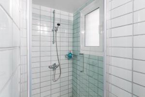 łazienka z prysznicem wyłożona białymi kafelkami. w obiekcie Be based in this groovy loft in the CITY CENTER!! w Atenach