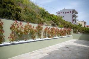 a fence with plants on the side of a hill at Lofos Apartments in Nea Peramos