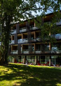 un edificio de apartamentos con sillas frente a un parque en Waldhaus Jakob, en Constanza