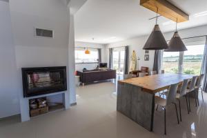 een keuken en een woonkamer met een tafel en een open haard bij The Maverick Surfvillas in Lourinhã