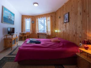 a bedroom with a large bed with a purple blanket at Hotel Elitza in Pamporovo