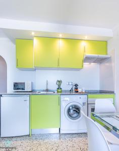 エンプリアブラバにあるHolidays P14 Sea Viewのキッチン(緑のキャビネット、洗濯機付)