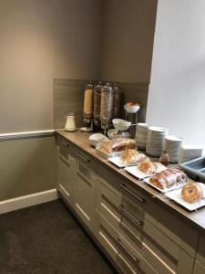 a kitchen with a counter with pastries on it at The Waverley Guest House in Inverness