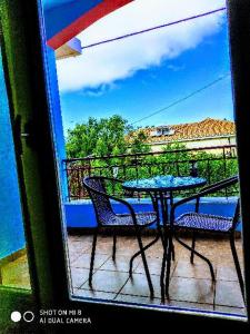 a table and chairs on a balcony with a view at Araxovoli Studios - Aραξοβολι Studios in Tsoukaladhes