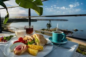 - une table avec une assiette de nourriture et une tasse de café dans l'établissement Migrator Intertidal Homestay, à Baisha