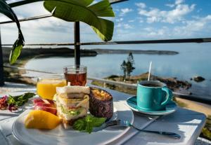 une assiette de nourriture sur une table avec une tasse de café dans l'établissement Migrator Intertidal Homestay, à Baisha