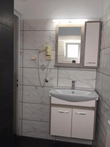W łazience znajduje się umywalka i lustro. w obiekcie Calypso Hotel w mieście Lipsi