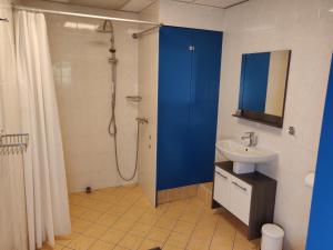 een badkamer met een blauw douchegordijn en een wastafel bij Guest House Ons Hoekje in Houten