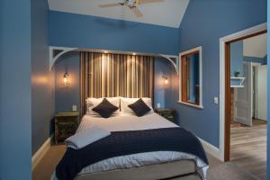 una camera da letto con pareti blu e un letto con cuscini di Oak Tree Lodge a Rhyll
