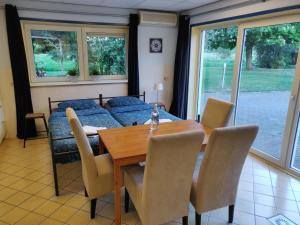 een eetkamer met een tafel en een bank bij Guest House Ons Hoekje in Houten