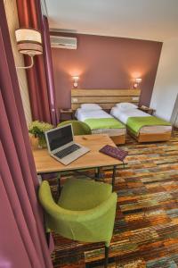 a hotel room with two beds and a desk with a laptop at Ukraina Hotel in Cherkasy