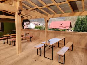 un pavillon avec des tables et des bancs sur une terrasse en bois dans l'établissement Casa Flori de Nuc, à Moneasa