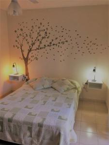 a bedroom with a tree with birds on the wall at CÓMODO DEPARTAMENTO EN ZONA CÉNTRICA in Rafaela
