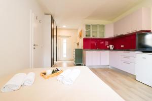 a kitchen with red cabinets and a table with towels at Dida Boža House in Vodice