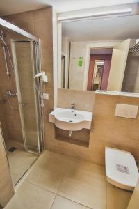 a bathroom with a sink and a shower and a toilet at Ukraina Hotel in Cherkasy