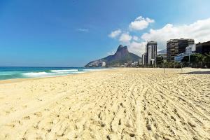 a view of a beach with a mountain in the background at Rio Spot Leblon D049 in Rio de Janeiro