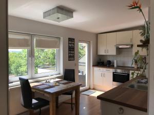 a kitchen with a wooden table with chairs and a dining room at Stadtdschungel FeWo mit Balkon in Cottbus