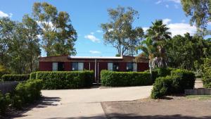 a red house with bushes in front of it at Coal n Cattle Hotel Motel in Moura