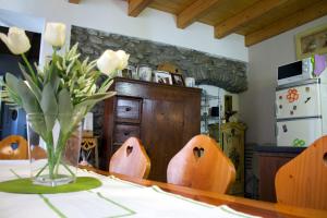 una mesa con un jarrón de flores sobre una mesa en La Casa Sul Sasso, en Dervio