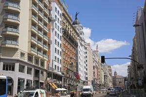 マドリードにあるGran Vía Suite II by Madflats Collectionの建物や信号が並ぶ賑やかな街道