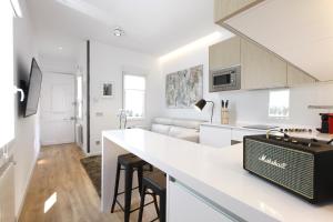 een witte keuken en een woonkamer met een aanrecht en een tas bij Latina Plaza in Madrid