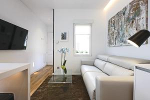 een witte woonkamer met een bank en een tv bij Latina Plaza in Madrid