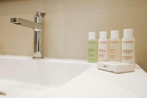 een wastafel met drie flessen lotion erop bij Latina Plaza in Madrid +19 foto's