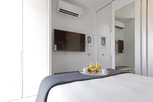 een slaapkamer met een bed met 2 glazen sinaasappelsap bij Latina Plaza in Madrid