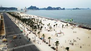 a crowd of people on a beach near the water at HalongSeoul Hotel in Ha Long