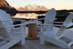 two white chairs and a table on a deck with a lake at Valberg High Quality Seaview Cabin in Valberg