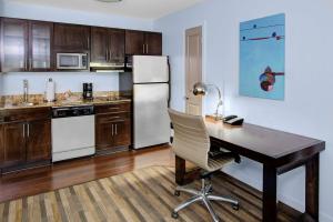 a kitchen with a desk and a refrigerator at Hyatt House Raleigh Durham Airport in Morrisville