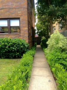 a sidewalk in front of a brick building at Guesthouse 83 in Cronulla