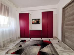 ein Zimmer mit roten Schränken und einem Gemälde an der Wand in der Unterkunft Violet Apartment-Brilliant Apartments in Constanţa