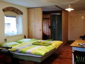 a bedroom with a bed with a green blanket on it at A-Sissy-Hof in Bischofstetten
