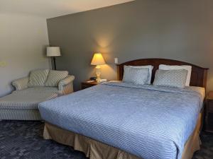 a hotel room with a bed and a chair at Beach Harbor Resort in Sturgeon Bay