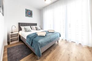 ein Schlafzimmer mit einem Bett mit einer blauen Decke in der Unterkunft Apartament Margo in Łeba