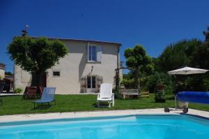 a house with a swimming pool in front of a house at Maison d'Hôtes Le Cadran Solaire in Courcelles