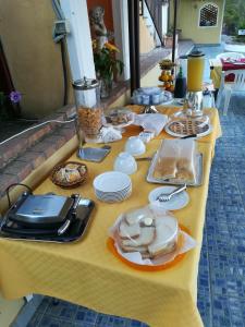 ein gelber Tisch mit Lebensmittelplatten drauf in der Unterkunft Hotel Villa La Colombaia in Agropoli